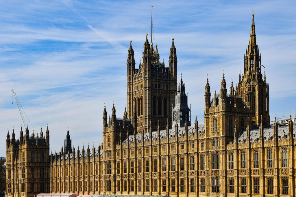 Gothic architecture of the Palace of Westminster against a clear blue sky in London, iconic British landmark