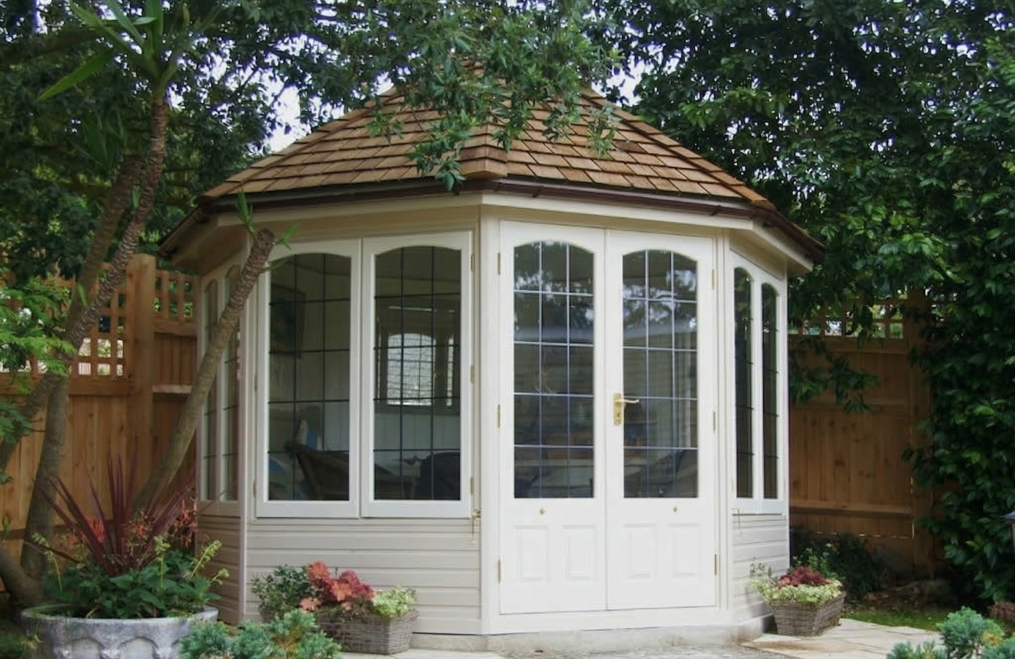 Cosy garden gazebo surrounded by lush greenery and potted plants, perfect for relaxation and outdoor gatherings